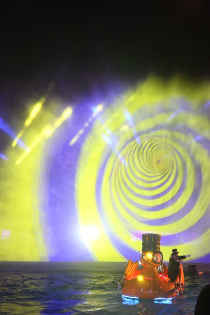 Pingüino intentando llevar a cabo su maléfico plan, el espectáculo Justice League: Rise of the Penguin en el Parque Warner