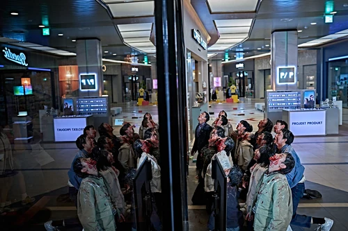 Colony: «Un grupo de personas ensangrentadas permanece arrodillado y mira hacia arriba en el interior de un centro comercial.»